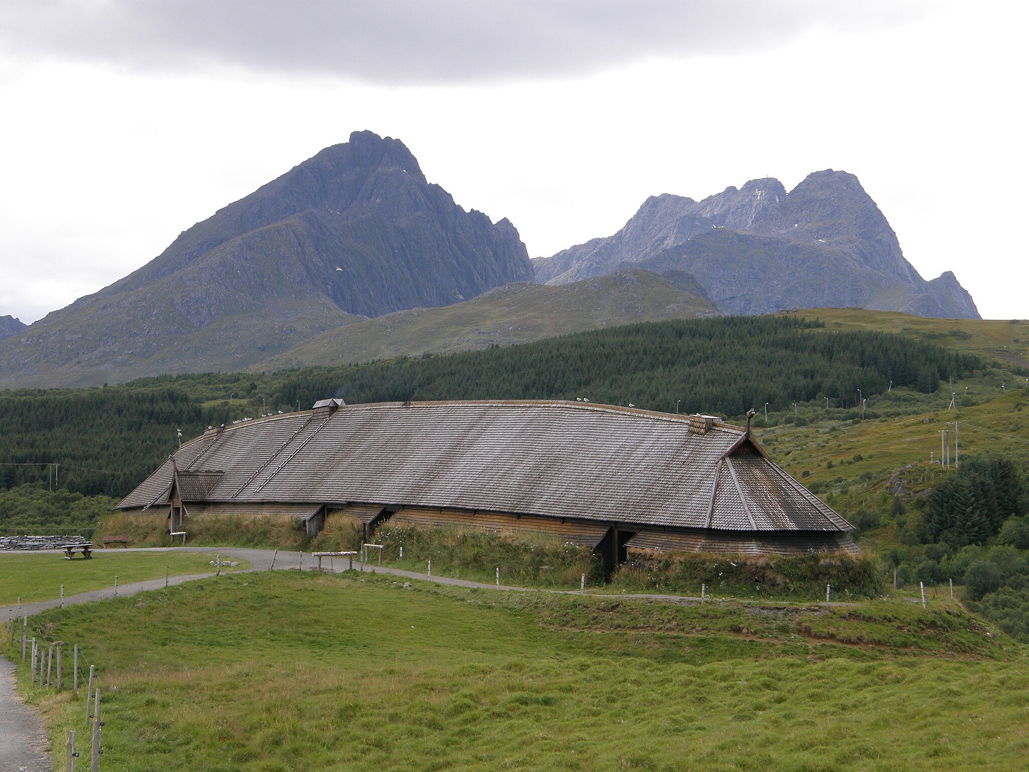 modern reconstruction of a Viking longhouse with mountains in the background.