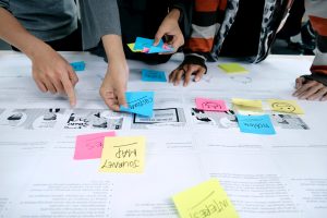 A group of people use post it notes to map out a plan for their company.