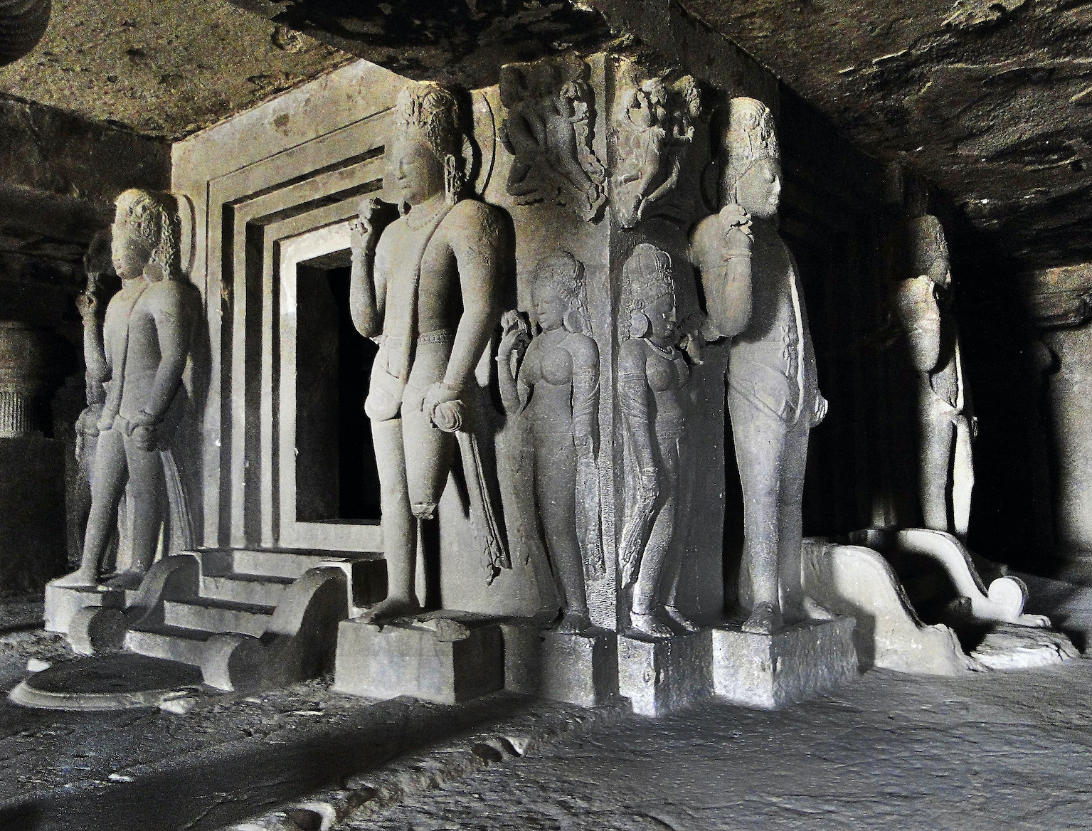 Figures stand besides the entry to a shrine inside a cave. Linga shrine in Cave 29, c. mid-6th century, Ellora (photo: Ronakshah1990, CC BY-SA 4.0)